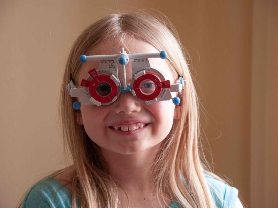 Kind mit einer Messbrille zur Bestimmung der Fehlsichtigkeit
