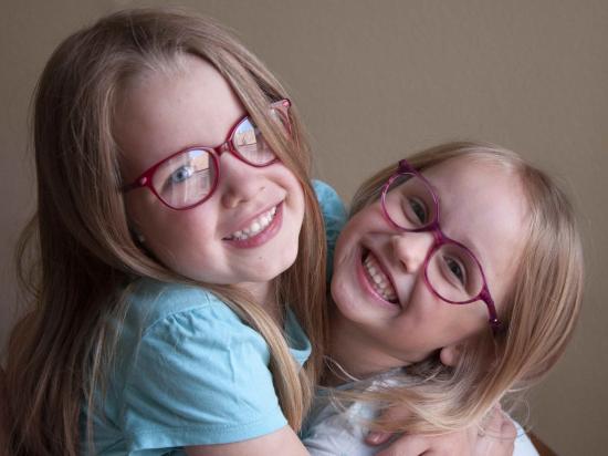 zwei lachende Mädchen mit Brille